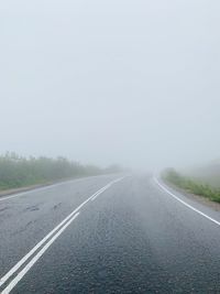Road by fog against sky