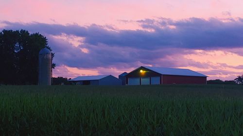 Built structure on field against sky at sunset