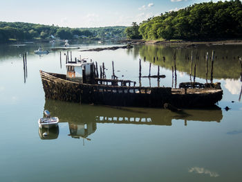 Boat moored on lake against sky