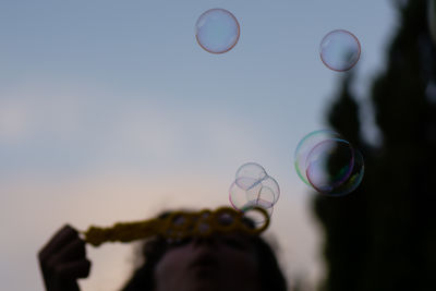 Cropped hand of woman holding bubbles