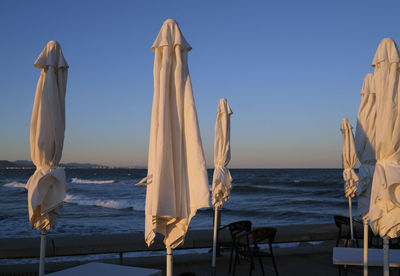 Closed patio umbrellas at a beach bar in valencia in wintertime