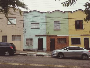 Cars on street against houses