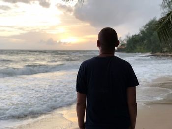 Rear view of man standing at beach