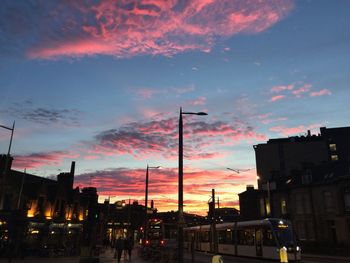 Cityscape against dramatic sky during sunset