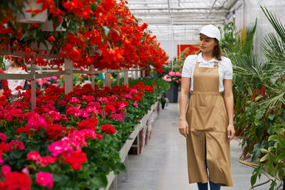 Woman standing by flowering plants