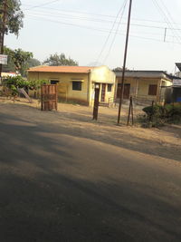 Houses by street against sky in city