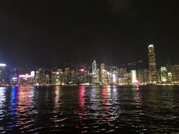 Illuminated buildings in city against sky at night