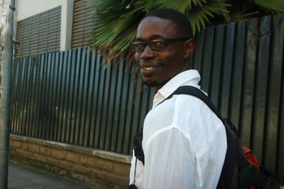 Portrait of smiling man walking on sidewalk in city