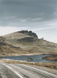 Scenic view of road by sea against sky