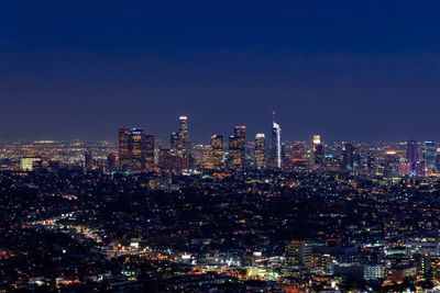 Illuminated cityscape against sky at night