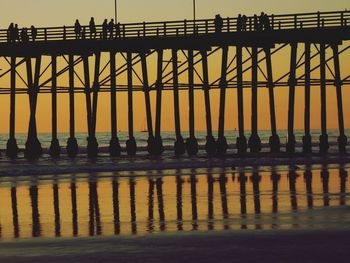 Low angle view of silhouette people standing against sky during sunset