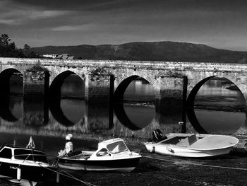 Boats moored on lake against sky