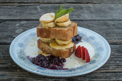 Close-up of banana sandwich served in plate on wooden table