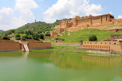 View of castle by river against sky