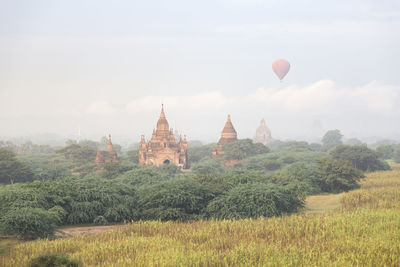 Hot-air balloon flying over old temples during sunrise in bagan