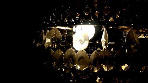 Close-up of illuminated light bulb against sky at night