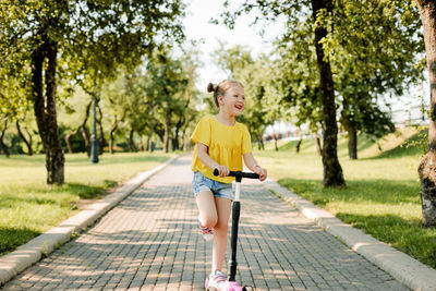 Portrait of boy walking on footpath