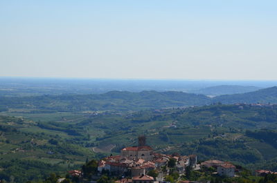 High angle view of cityscape by sea against clear sky