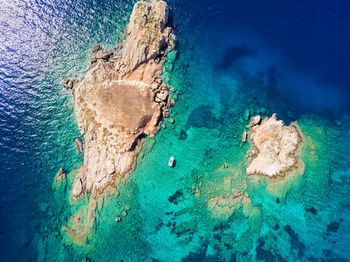 Aerial view of rock formations amidst blue sea
