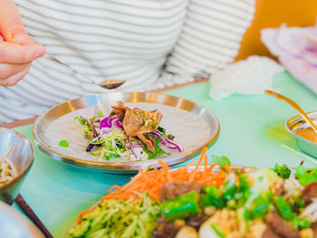 Cropped hand of woman having food on table