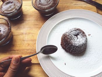 Cropped image of person having chocolate coulant in plate