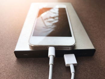 Close-up of mobile phone charging on table