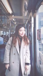 Portrait of woman standing at railroad station