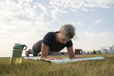 Mature woman practicing plank position on exercise mat