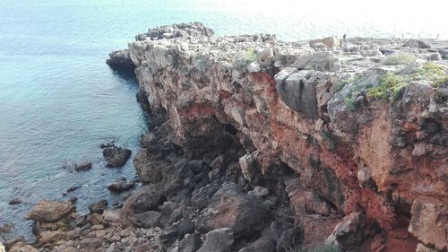 Rock formation on beach against sky