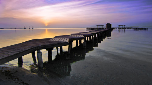 Pier on sea during sunset