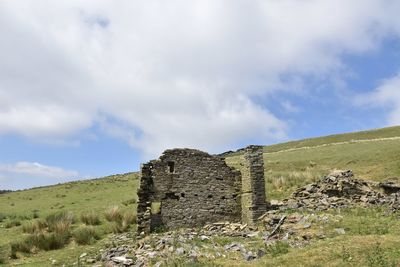 Old stone ruins in a field against sky