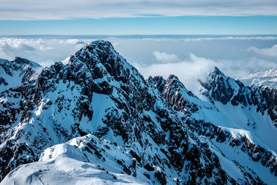 Scenic view of snowcapped mountains against cloudy sky