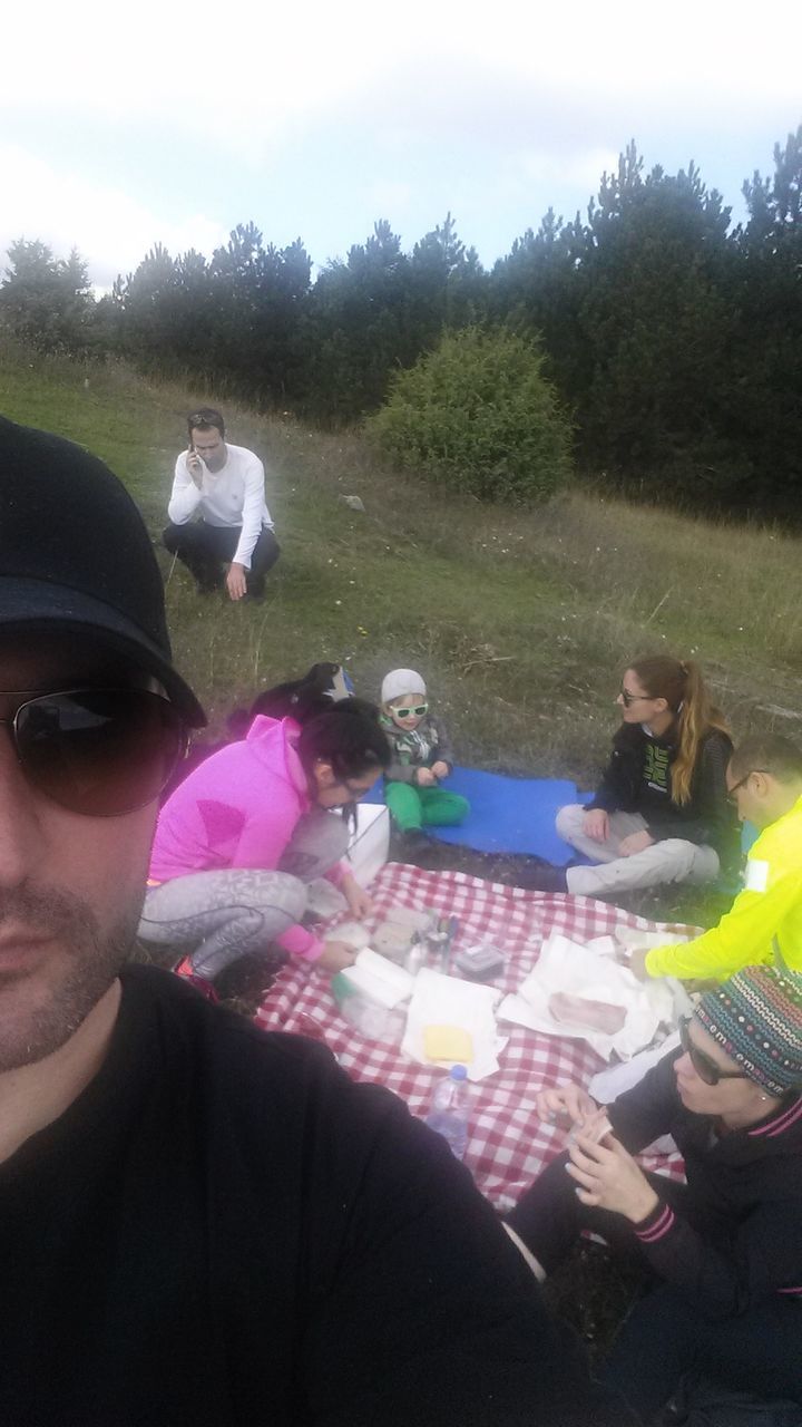 leisure activity, lifestyles, holding, person, sunlight, men, childhood, outdoors, sitting, day, enjoyment, unrecognizable person, playing, togetherness, incidental people, fun, casual clothing