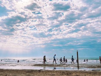 People on beach against sky