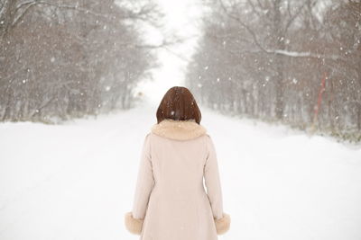 Rear view of woman on snow covered field