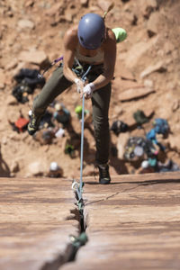 High angle view of female hiker clambering on mountain