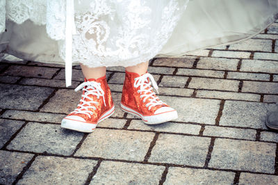 Low section of woman standing on footpath