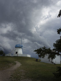 Built structure on landscape against cloudy sky