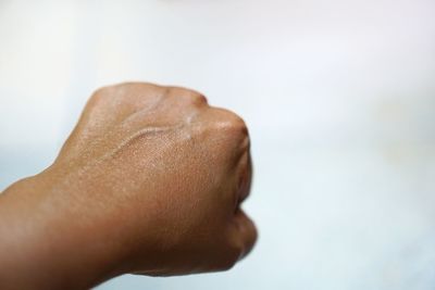 Close-up of hand over white background