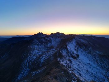 Scenic view of snowcapped mountains against sky during sunset