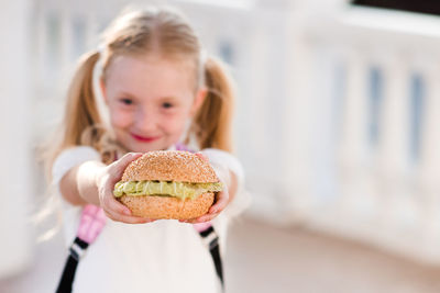 Portrait of cute girl holding hamburger