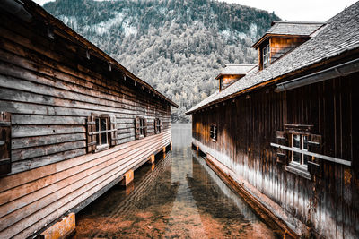 Old building by snowcapped mountain during winter