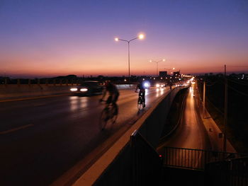 Cars on road against sky at night