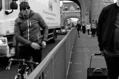 Man standing on bicycle in city