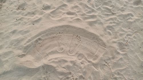 High angle view of footprints on sand at beach