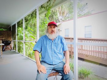 Portrait of man sitting in a screened porch