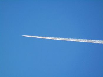 Low angle view of vapor trail in blue sky