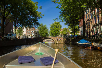 Canal in city against sky