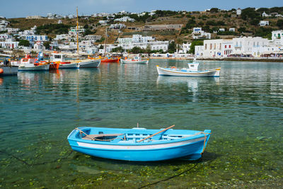 Boats moored in sea by buildings in city