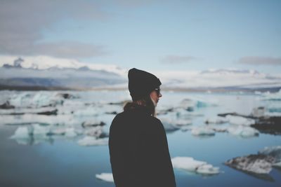 Woman standing against frozen lake